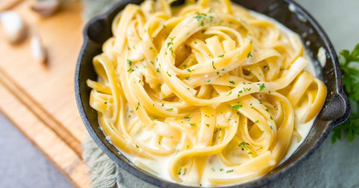 Prato de macarrão ao molho branco com carne.